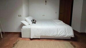 A bedroom with a bed, a nightstand, and a wooden ceiling. - A Cozy Wooden Duplex casa Ski Retreat| 2BR,2BA in a Peaceful Town near Camprodón (Sant Pau de Segúries)