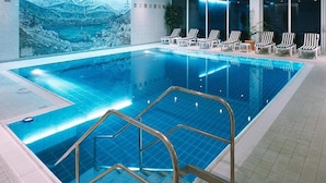 An indoor swimming pool with a view of a mountainous landscape, lounge chairs, and a tiled floor. - 1 Person Holiday Park Home in Garmisch-partenkirchen (Garmisch-Partenkirchen)