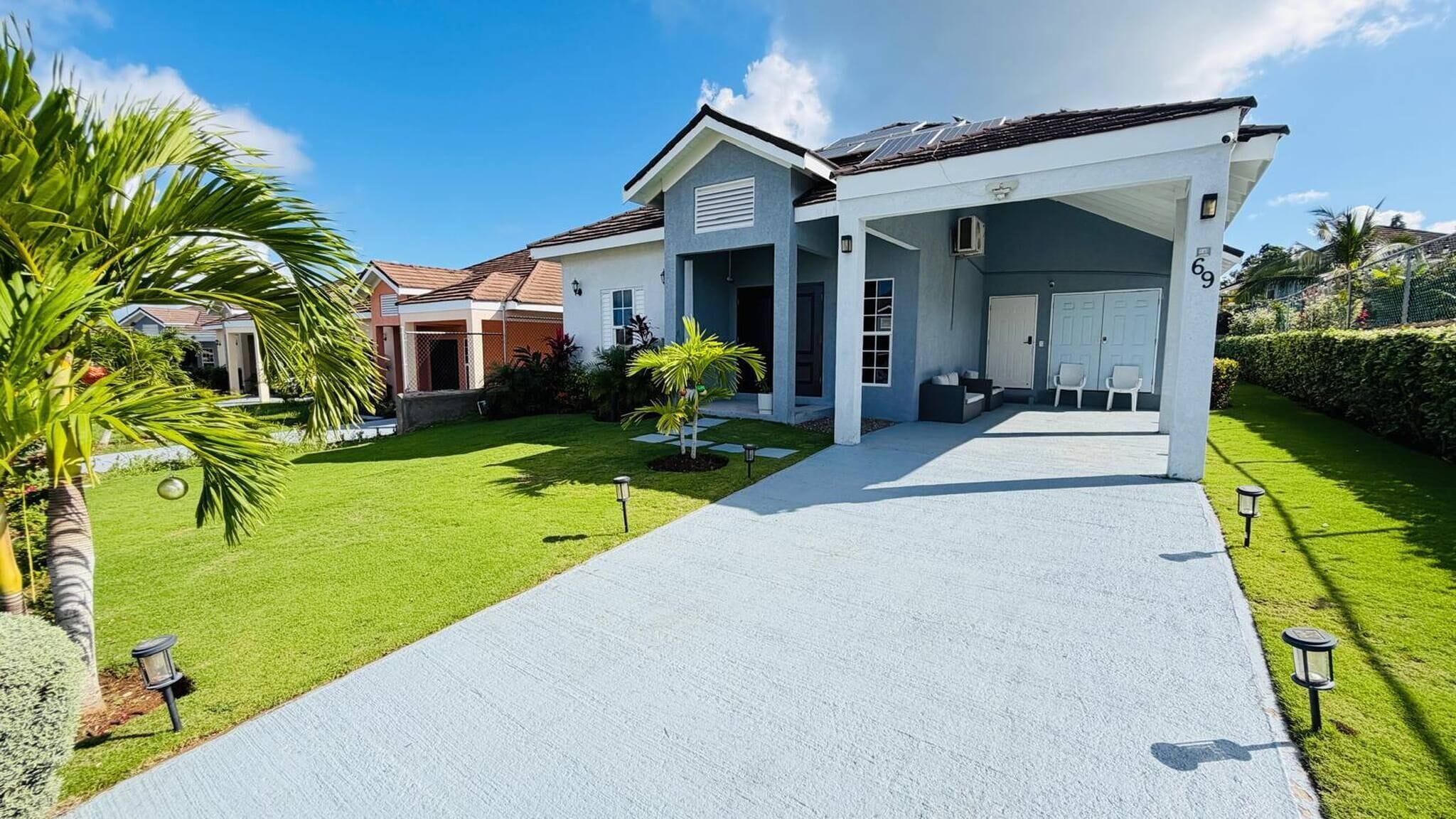 A modern two-story house with a covered driveway, a garage, and a well-maintained lawn.