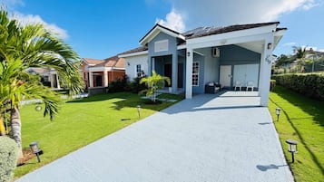 A modern two-story house with a covered driveway, a garage, and a well-maintained lawn.