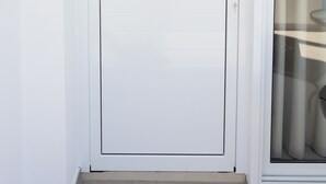 Una porta bianca con il numero 2 sopra, una maniglia tonda e una porta in vetro sulla destra.