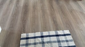 Eine moderne Küche mit weißen Schränken, einem Edelstahlkühlschrank und einem Holzespeisetisch.