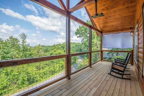 Una terraza de madera con vistas a un paisaje boscoso.
