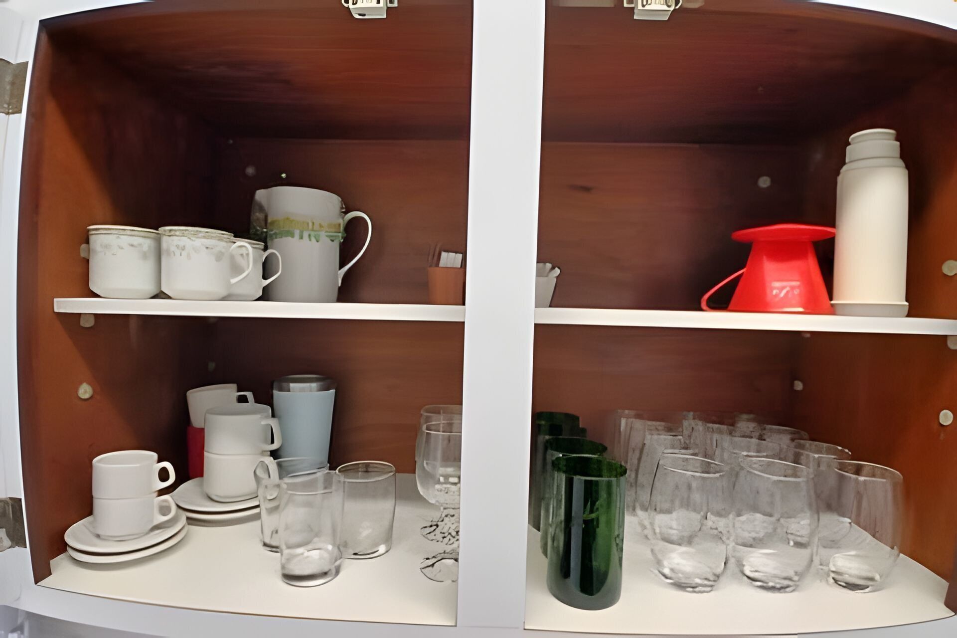 Eine Küchenschrank mit Regalen voller Küchenutensilien.