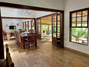 A spacious dining area with wooden furniture and a television.