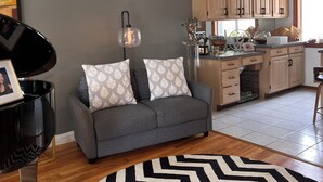 A modern living room with a grey sofa, patterned cushions, a black floor lamp, and a black and white rug. - Spacious 4-bedroom house in northern Westchester with sweeping views (Montrose)
