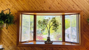 A room with a large window, wooden walls, and a potted plant. - Spacious 4-bedroom house in northern Westchester with sweeping views (Montrose)