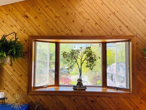 A room with a large window, wooden walls, and a potted plant. - Spacious 4-bedroom house in northern Westchester with sweeping views (Montrose)