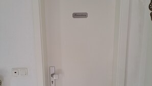 A white door with a label 'Feriemwohnung' and a keyhole lock. - Rieslingglück Vacation Rental (Trittenheim)