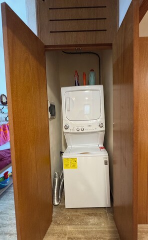 Ein kleiner Waschraum mit einer Waschmaschine mit Frontlader, einem Trockner und einem Holzschrank darüber.
