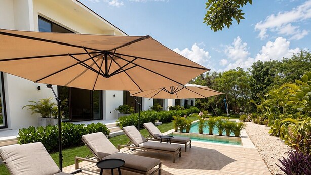 A deck with lounge chairs and umbrellas, a swimming pool, and a modern building. - Perfect 1-bedroom apartment with AC in welcoming Puerto Aventuras (Puerto Aventuras)