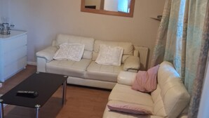 A living room with a sofa, a coffee table, and a mirror on the wall. - North Dublin 2-bed House, Sleeps 4 (Dublin)
