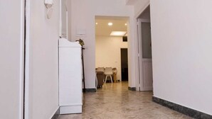 A hallway with a tiled floor, a white refrigerator, and a dining area in the background. - Experience Palermo in total comfort: a bright, cozy, and centrally located home. (Palermo)