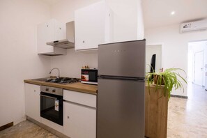 A modern kitchen with white cabinets, a stainless steel refrigerator, a microwave, and a gas stove. - Experience Palermo in complete comfort: a bright, cozy, and centrally located home. (Palermo)