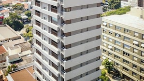 Um edifício alto com várias varandas e grandes janelas.