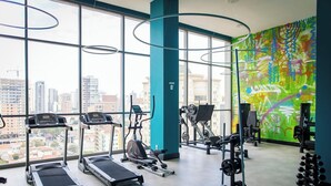 Uma academia com esteiras, elípticos e equipamentos de musculação.