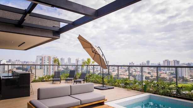 Terraço no telhado com piscina, área de estar e vista para a cidade.