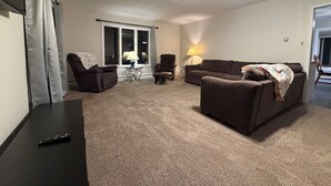 A living room with a ceiling fan, two couches, a table, and a lamp. - Riverfront escape at Q’s River Place, a 3 bedroom year round getaway (Hersey)