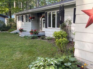 Ein Haus mit Veranda, Stufen, Topfpflanzen und einer roten Stern-Dekoration.