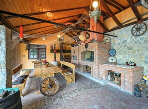 Un interior rústico con chimenea de ladrillo, muebles de madera y pared de piedra.