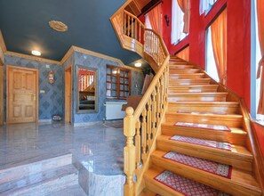 A spacious room with a marble floor, a wooden staircase with red runners, and a view of a red wall and window. - Requiem Rustical Heaven Villa With Outdoor Pool (Bednja)