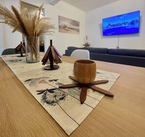 A dining table with a woven placemat, a wooden bowl, and decorative wooden stands. - A Home Away from Home: Apartment Countess•6per•2rec (Ciudad de México)