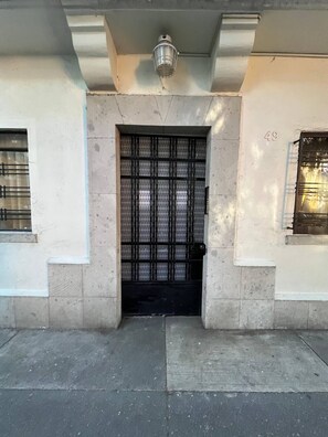 A building entrance with a metal gate, a number '49' on the wall, and a small window on the left. - A Home Away from Home: Apartment Countess•6per•2rec (Ciudad de México)