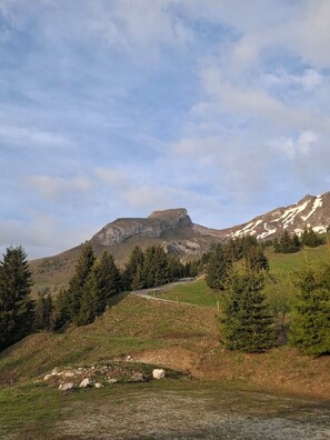 Eine gebirgige Landschaft mit blauem Himmel, einem gewundenen Pfad und spärlicher Vegetation.