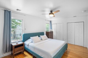 A bedroom with a bed, nightstand, dresser, and a ceiling fan. - Cozy 3-bedroom apartment in fantastic Jersey City, easy access to NYC (Jersey City)