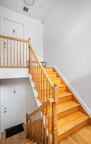 A wooden staircase with a handrail leading to a landing. - Cozy 3-bedroom apartment in fantastic Jersey City, easy access to NYC (Jersey City)