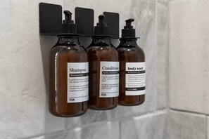 Three bottles of toiletries on a wall-mounted holder. - Waterfront: Hot tub, pool table, river, fishing (McCurtain County)