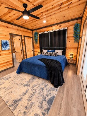 A bedroom with a bed, a ceiling fan, and a nightstand. - Waterfront: Hot tub, pool table, river, fishing (McCurtain County)