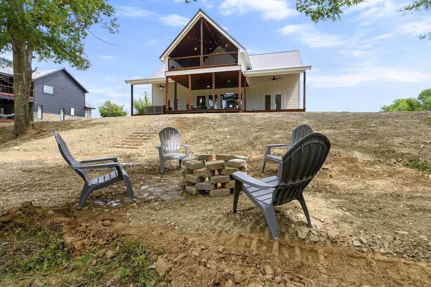 Een tweelaags huis met een overdekte veranda en een terras.