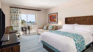 A hotel room with a bed, a TV, a desk, and a balcony with a view. - Aruba Marriott Surf Club - Oceanside 1 bedroom Studio with kitchenette, sleeps 4 (Noord)