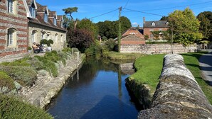 A narrow canal with stone walls, a stone bridge, and traditional buildings with arched windows. - Byre House (Sleeps 4) - Sutton Waldron , Shaftesbury sleeps 4 guests  in 2 bedrooms (Blandford)