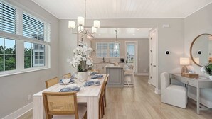 A spacious dining area with a long table, chairs, and a chandelier. - Luxury Waterfront Home with Private Dock and Pool Manatee Cove at Hunters Point (Cortez)