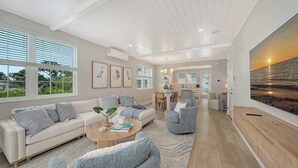 A spacious living room with a large window, a dining area, and a kitchen. - Luxury Waterfront Home with Private Dock and Pool Manatee Cove at Hunters Point (Cortez)
