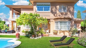 A two-story house with a swimming pool, outdoor furniture, and a well-maintained garden. - LXR Villa Elysée: 4 Bedrooms, Pool, and Amenities (AN)