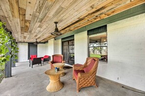 A covered outdoor seating area with wicker furniture and a concrete floor. - Pet-Friendly Lockhart Home With Private Yard! (Lockhart)