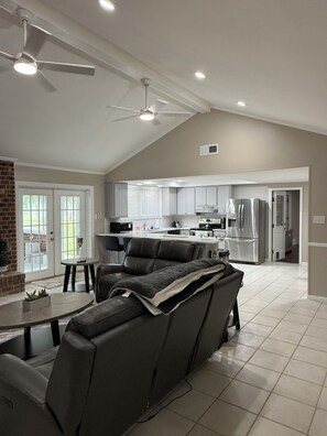 A modern kitchen with stainless steel appliances, a dining area with a leather couch, and a ceiling fan. - Peaceful Home spacious 4 Bedrooms in Savannah
STR 026567 (Savannah)