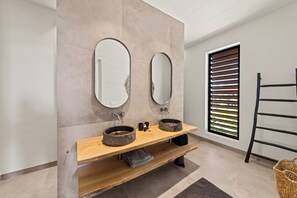 A modern bathroom with two mirrors, a wooden vanity, and a window with blinds. - Villa Quatrosol - an exclusive private resort under the sun! (Jan Thiel)