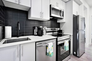 A modern kitchen with stainless steel appliances, a microwave, and a refrigerator.
