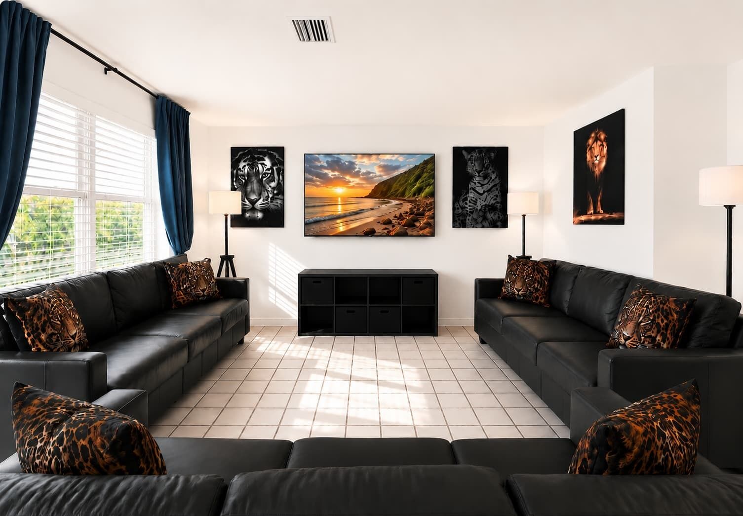 A modern living room with two black leather sofas, a large painting of a sunset, and a fireplace.