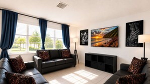 Ein Wohnzimmer mit einer Sofagarnitur, einem Fernsehschrank und Kunstwerken an den Wänden.