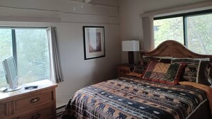 Un dormitorio con cama, mesita de noche, lámpara, cómoda y ventana.