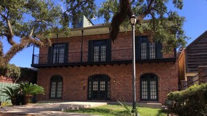 A two-story brick building with arched windows and a balcony. - Comfort and Style, Modern Corporate Apartment in Pascagoula (Pascagoula)