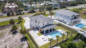 Une maison à deux étages avec une piscine, un patio couvert et une cour clôturée.
