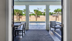 Un patio abierto con piscina, cerca de madera y mobiliario exterior.