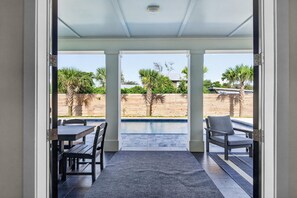 An open patio area with a pool, outdoor furniture, and a view of the surrounding landscape. - Luxury Beach Retreat I Heated Saltwater Pool (Saint Augustine)