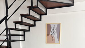 Ein modernes Interieur mit einer Wendeltreppe, einem Glastisch mit Stühlen und einem flauschigen Teppich.